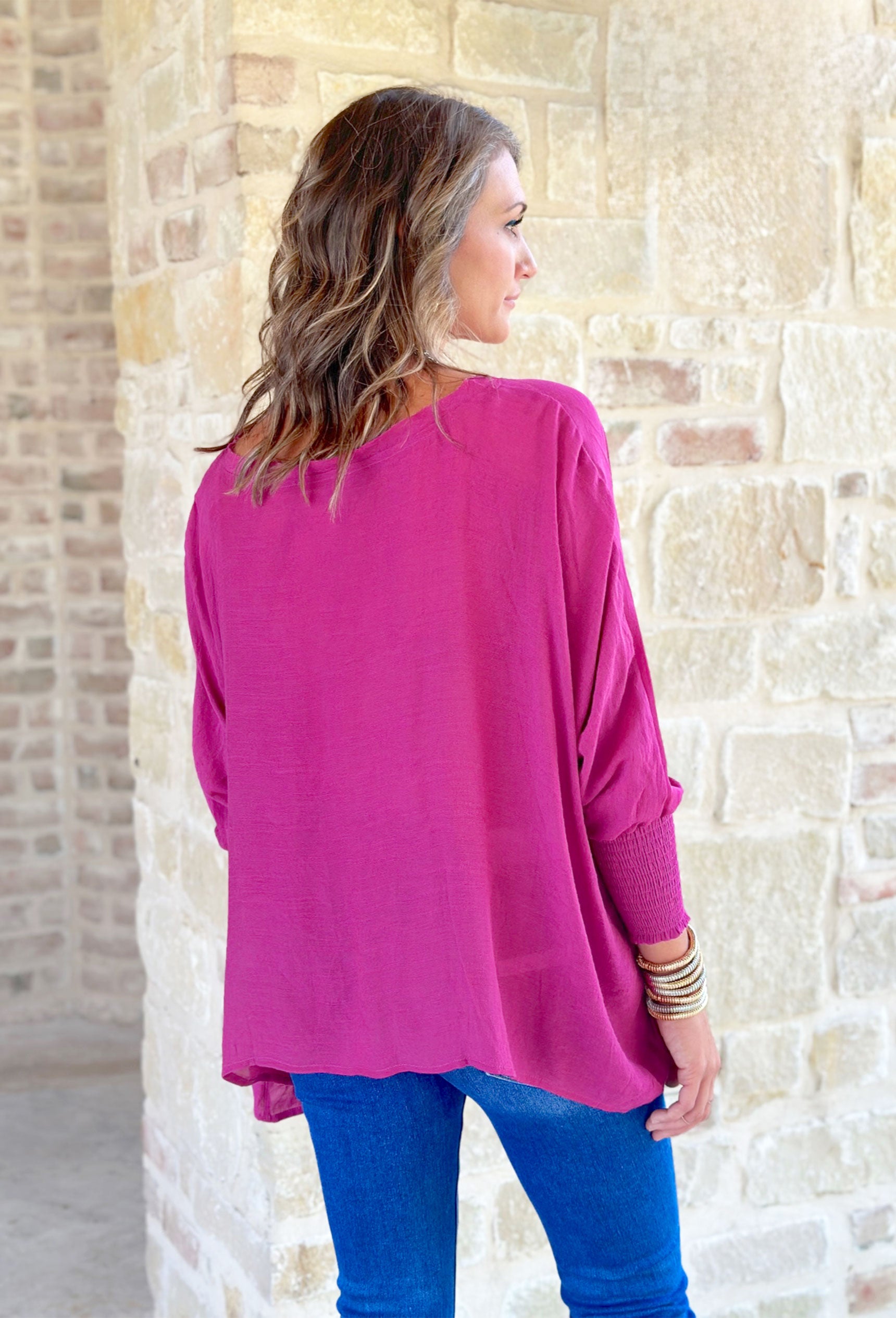 Long Time Gone Top, fuchsia long sleeve blouse with cinching on the wrists and asymmetrical hemline 
