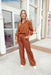 Stay With Me Set, satin button up top with satin wide leg pants that have an elastic waist band, both pieces are a rust color