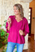 Thinking Of You Top, fuchsia long sleeve blouse with ruffles on the wrist and collar, soft v-neck line and tassels on the collar