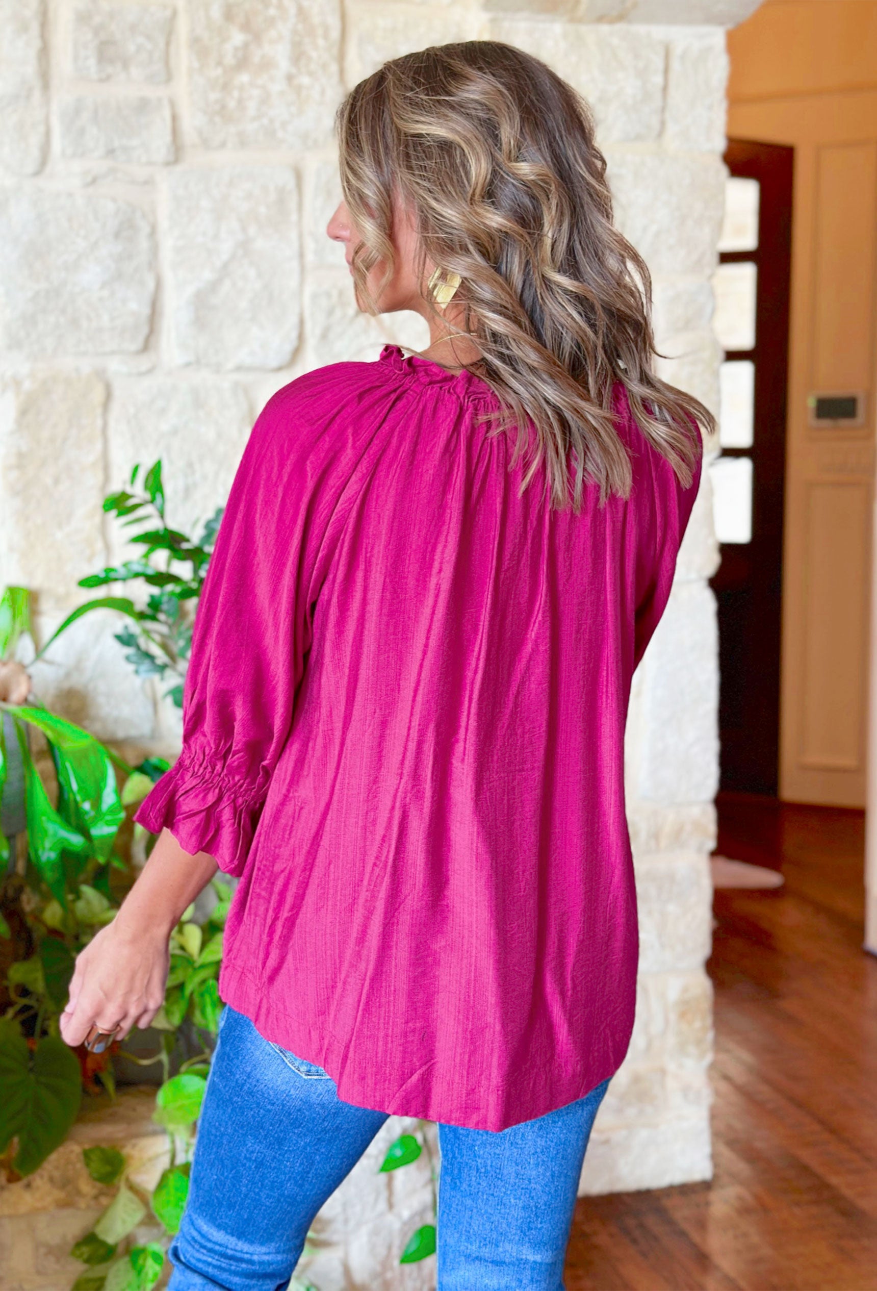 Thinking Of You Top, fuchsia long sleeve blouse with ruffles on the wrist and collar, soft v-neck line and tassels on the collar