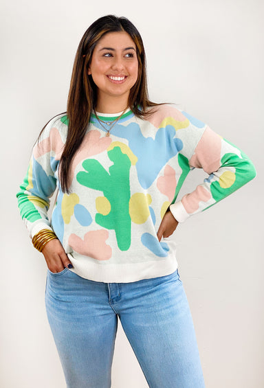 New York Nights Sweater, white sweater with yellow, pink and green abstract design, striped neckline