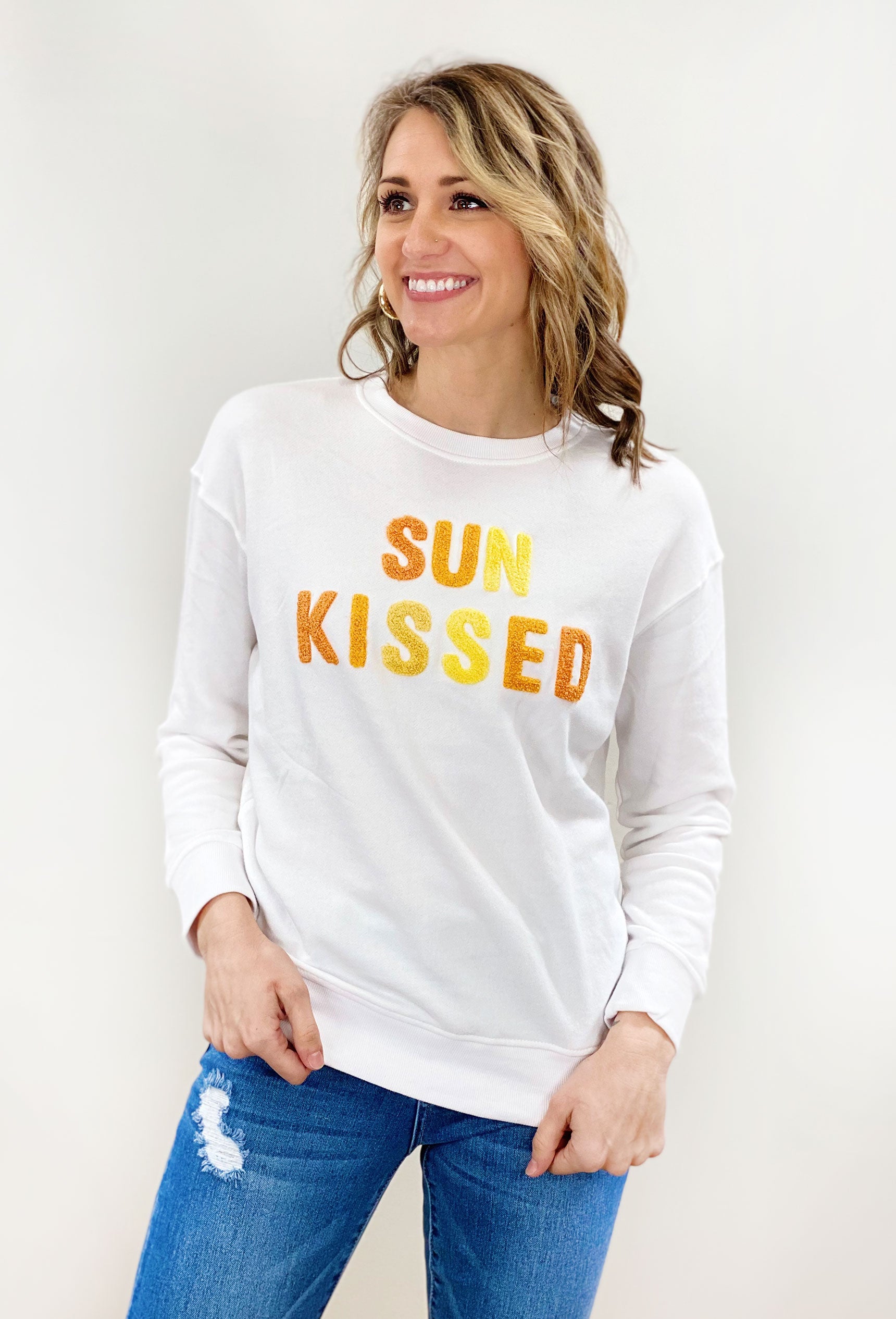 Sun Kissed Pullover, white pullover with "sun kissed" patches in different shades of yellow and orange across the chest