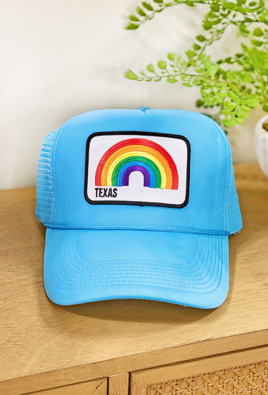 Texas Trucker Hat, blue trucker hat with white patch and rainbow that says Texas under the rainbow