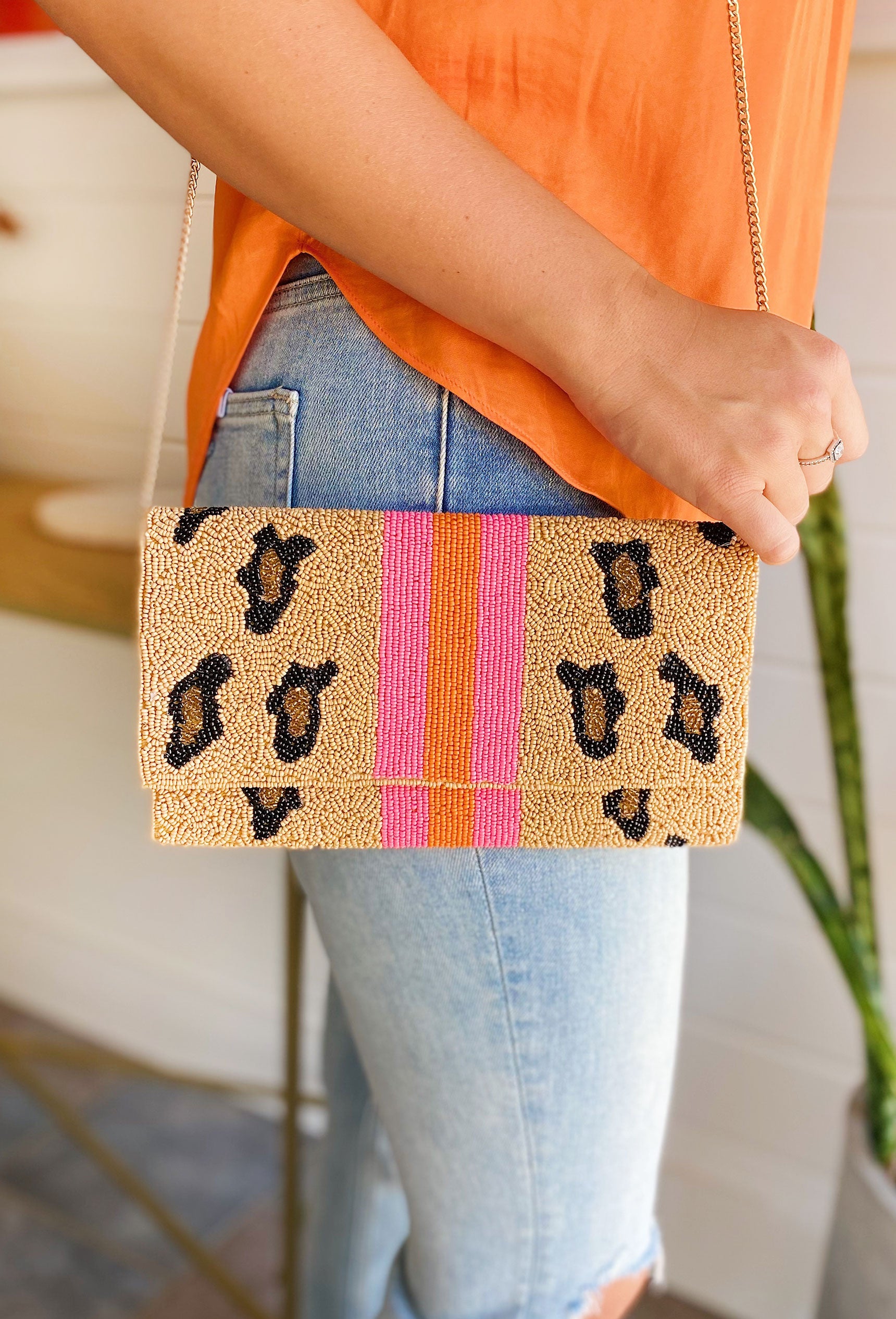 Wilder Times Beaded Clutch, brown beaded bag with leopard spots, pink and orange stripe down the middle, removable crossbody strap