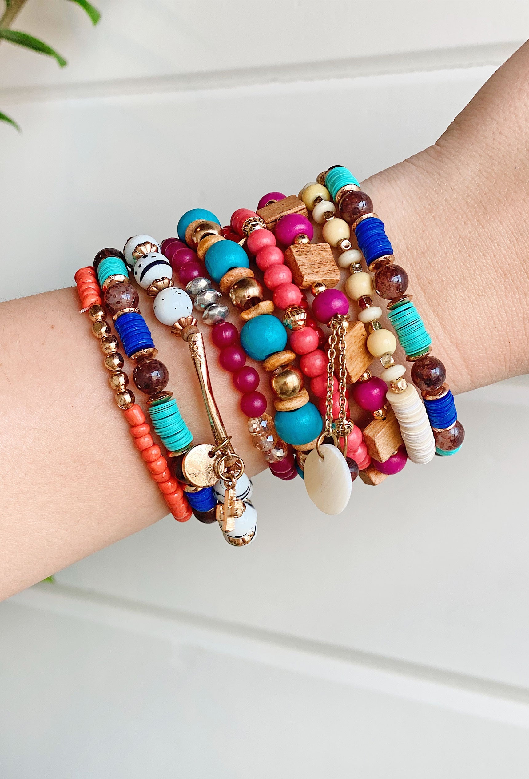 Cabana Retreat Bracelet Set, set of 10 bracelets, variety of different colored beads with wooded beads and gold beads, charms hanging from few bracelets