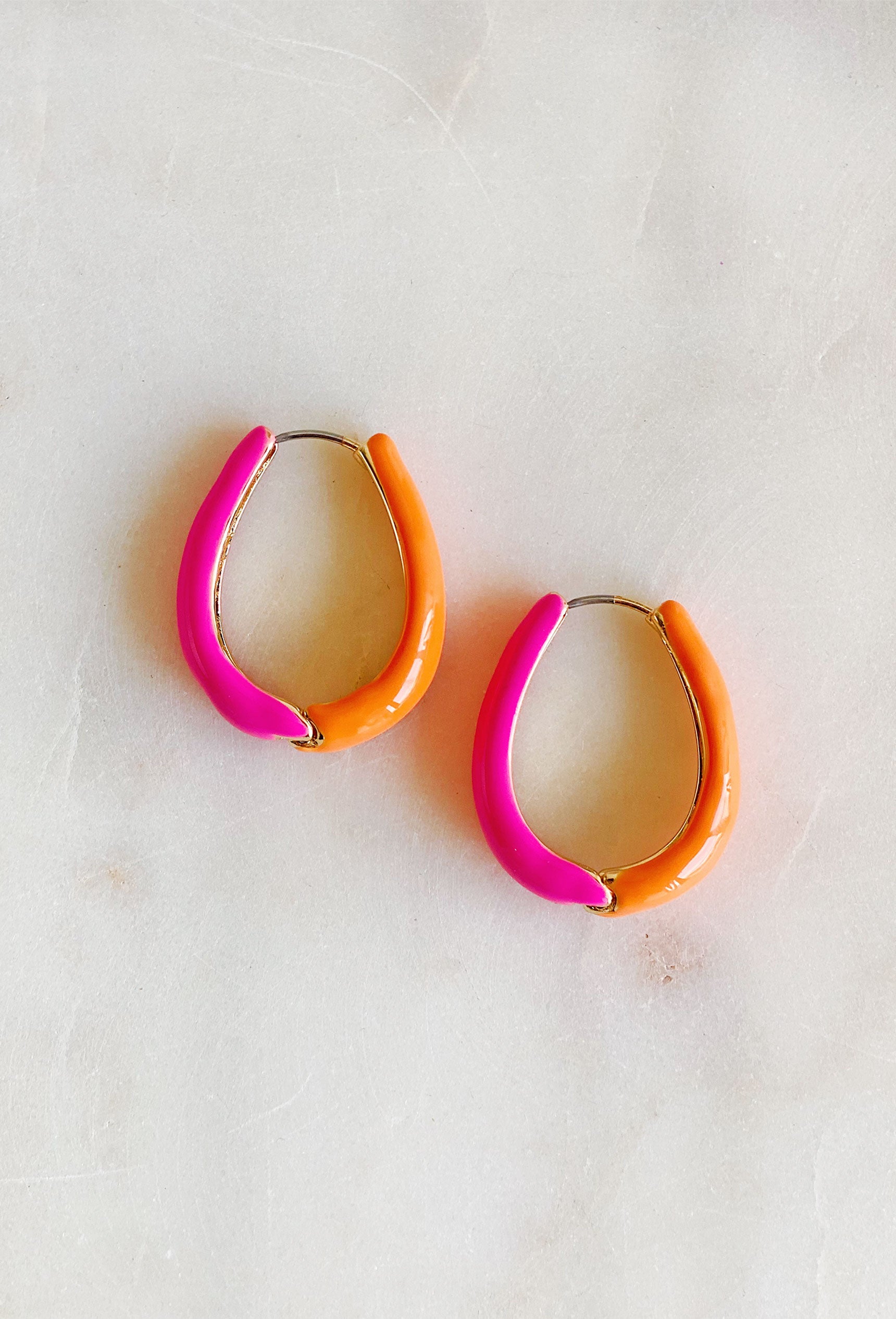 On Sunshine Time Earrings, half pink and half orange hoop earrings